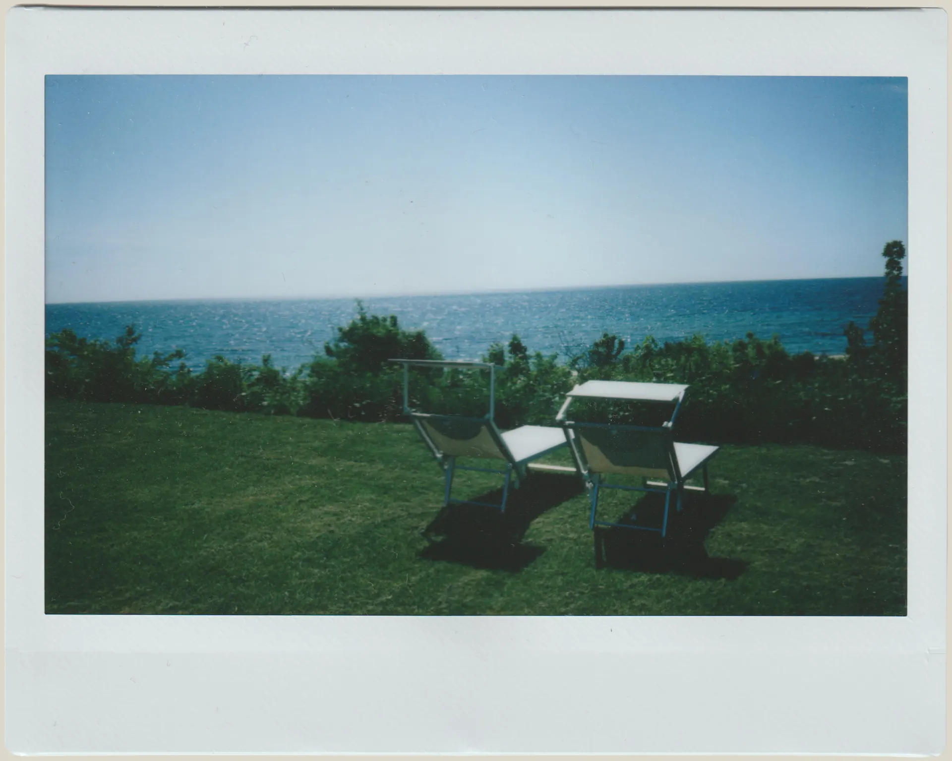 Two lounge chairs facing the sea from the Villa Hesnæs lawn.